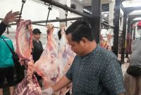 Warga dan petugas UPTD RPH Jatimulya sedang melaksanakan pemotongan hewan kurban Idul Adha 1446 H dengan standar halal dan pemeriksaan kesehatan hewan yang ketat, memastikan daging kurban aman dan berkualitas untuk masyarakat Kabupaten Bekasi.