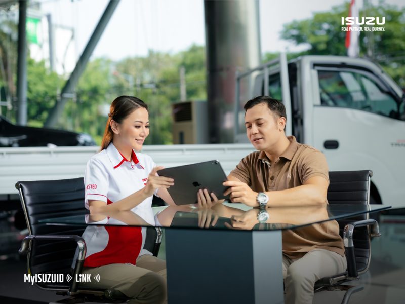 Petugas Isuzu menjelaskan penggunaan aplikasi MyIsuzuID dan sistem telematika Isuzu Link kepada pelanggan. Melalui integrasi teknologi digital ini, pemilik armada dapat memantau kondisi kendaraan, perilaku pengemudi, hingga jadwal perawatan secara real-time untuk meningkatkan keselamatan berkendara dan efisiensi operasional. (Foto: Dok. PT Isuzu Astra Motor Indonesia).