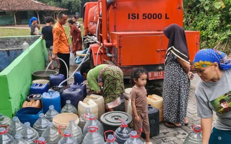 Warga mengantre untuk mendapatkan bantuan air bersih dari mobil tangki BPBD Kabupaten Bekasi di wilayah terdampak kekeringan. Sejak 9 Juni 2026, BPBD telah menyalurkan 65.000 liter air bersih kepada 909 kepala keluarga sebagai upaya memenuhi kebutuhan air bersih selama musim kemarau.