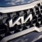 Logo baru Kia terpasang pada grille depan kendaraan. Emblem yang diperkenalkan sejak 2021 ini menjadi simbol transformasi merek menuju penyedia solusi mobilitas masa depan dengan filosofi Symmetry, Rhythm, dan Rising. Foto: Dok. Kia